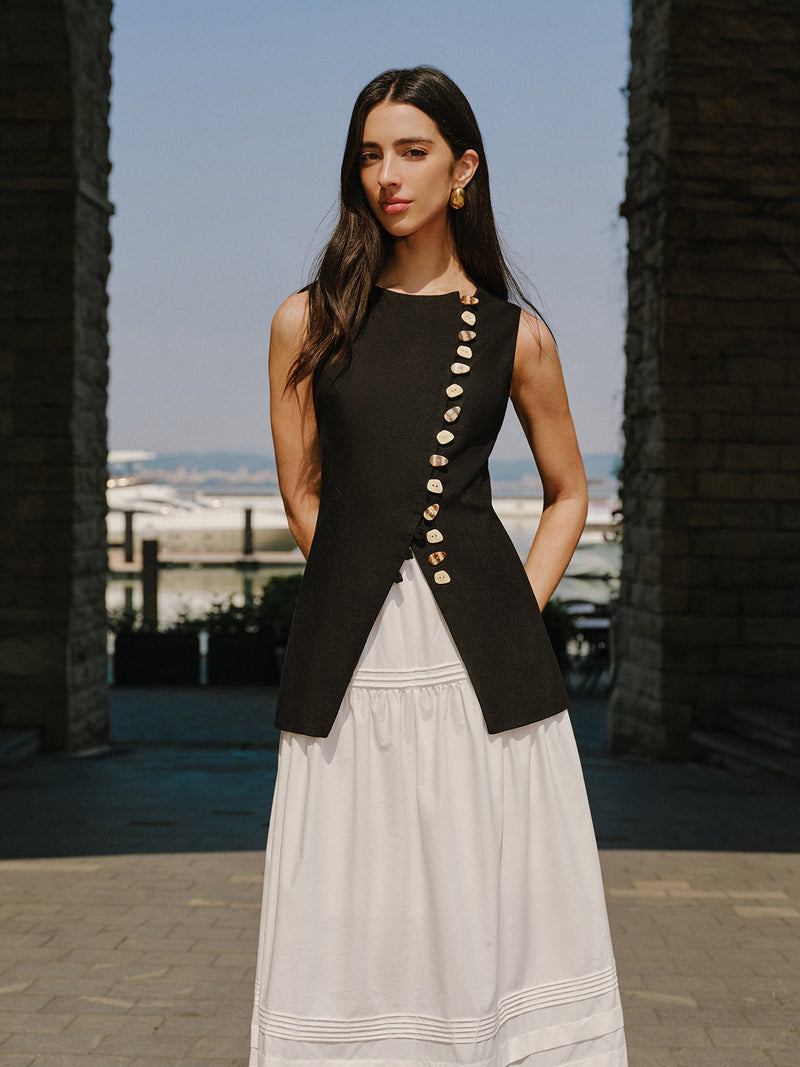 LA FINE FLEUR Linen Vest with elegant button details paired with a flowing white skirt.