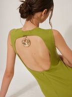 Sleeveless olive green mini dress with an open-back cutout and gold medallion accent.