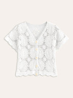 White, short-sleeve crochet cardigan with V-neck, scalloped edges, cream buttons, and lacy texture.