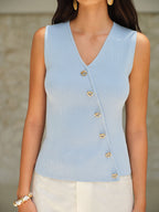 Light blue BYPINKYPARIS V-Neck sleeveless top with elegant gold buttons and light pants.