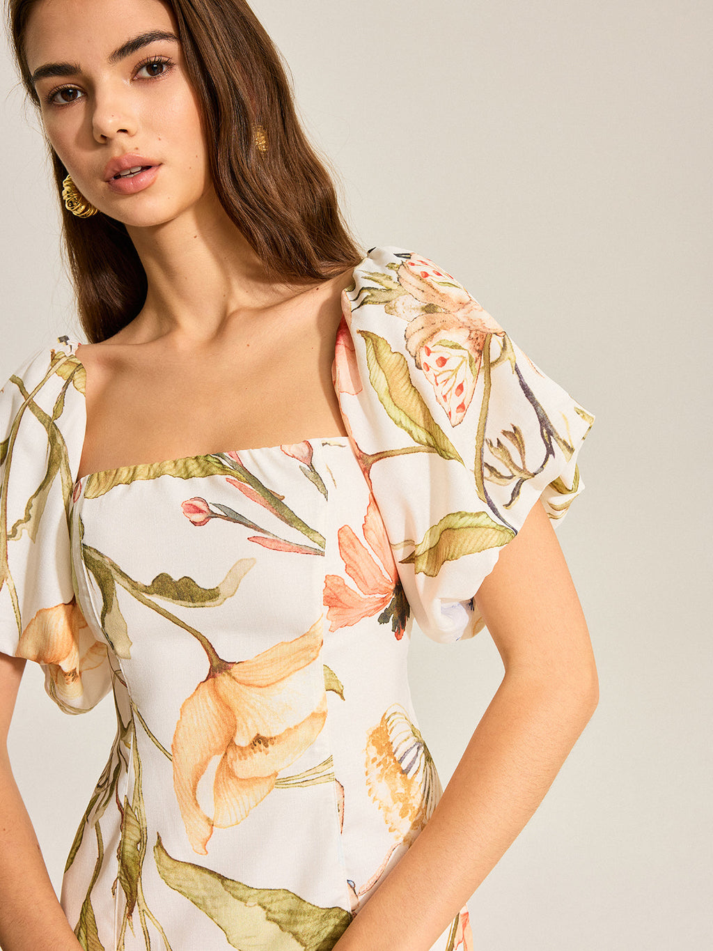 LA FINE FLEUR backless dress featuring a floral pattern and puff sleeves.