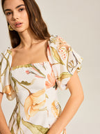 LA FINE FLEUR backless dress featuring a floral pattern and puff sleeves.