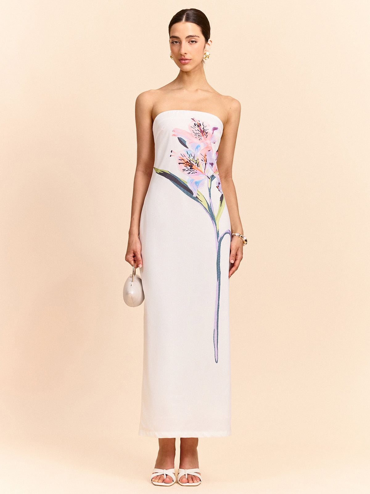 A white strapless maxi dress featuring an elegant floral design along the front panel.