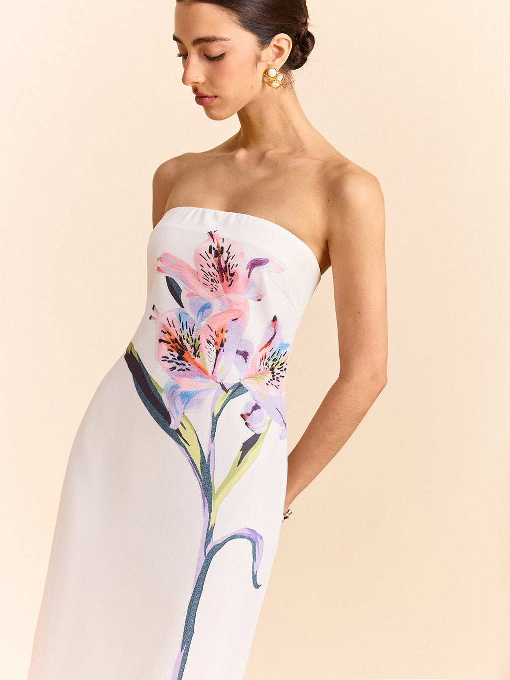 Strapless maxi dress with a white bodice and vibrant pink and purple lily floral design.
