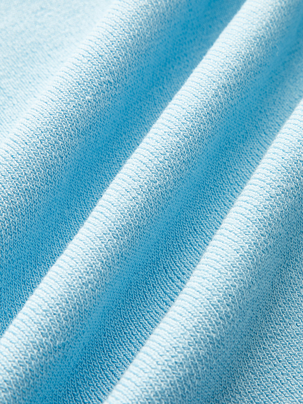 Light blue textured knit vest with shell buttons, soft folded ridges, and cozy finish.