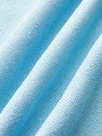 Light blue textured knit vest with shell buttons, soft folded ridges, and cozy finish.