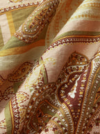 Paisley-patterned midi dress with spaghetti straps in gold, brown, olive green, and cream.