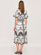 LA FINE FLEUR white bohemian floral V-neck midi dress with black palm tree and bird prints.