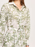 Green leafy print belted midi dress with long sleeves, collar, and side slits.