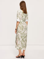 A green leafy print belted midi dress with side slits, rolled-up sleeves, and waist tie.