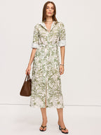 A light green and white leaf print belted midi dress with side slits, collared neckline.