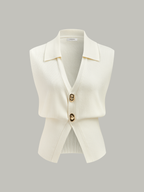Sleeveless cream textured knit vest with collar and two large metallic buttons.