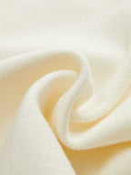 Cream-colored ribbed knit vest with metallic buttons, showcasing soft drape and textured fabric.