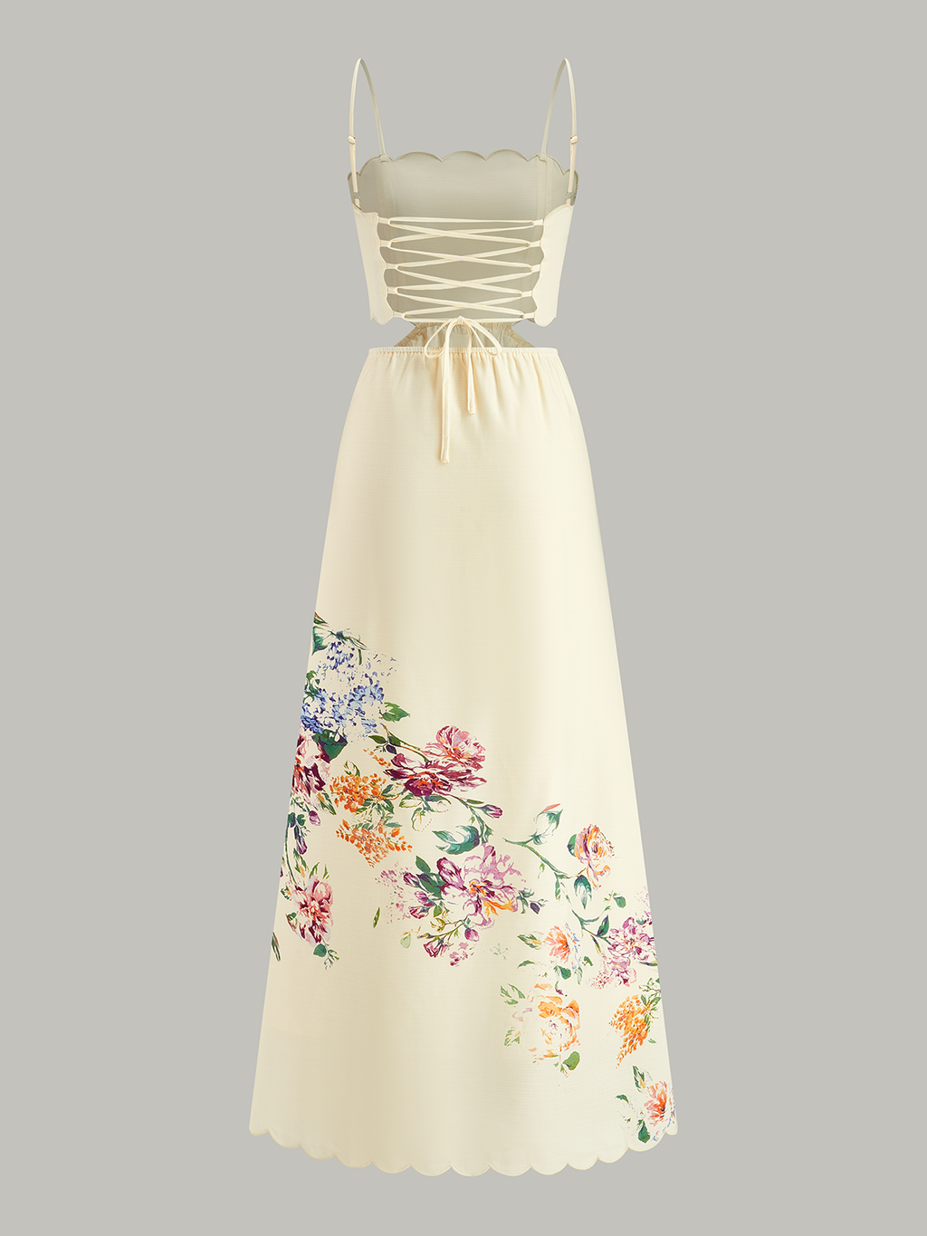 Sleeveless cream dress with lace-up back, scalloped edges, and colorful floral printed skirt.
