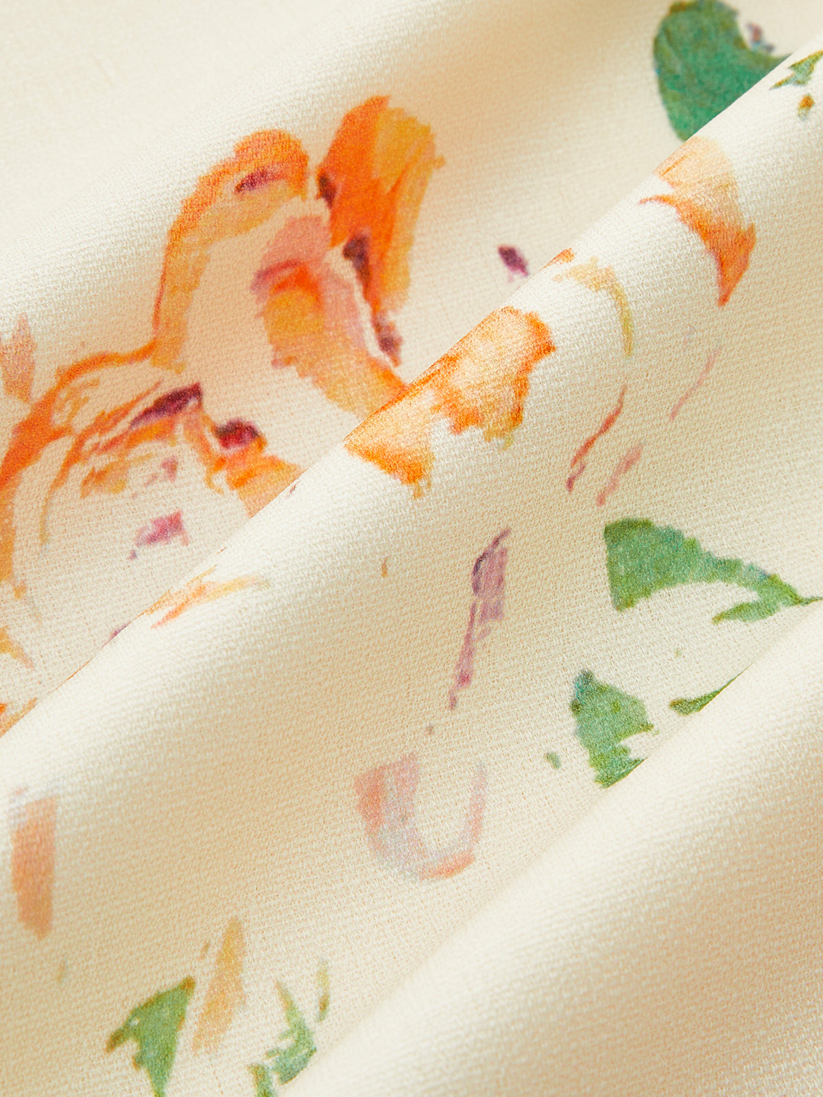 Sleeveless cream dress with orange and green floral print, lace-up back, textured folds.