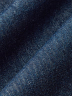 Textured blue denim wide-leg trousers with gentle folds and subtle tones for a relaxed fit.