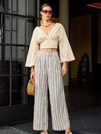 Slim fit V-neck cropped tee paired with striped wide-leg pants and casual sandals.