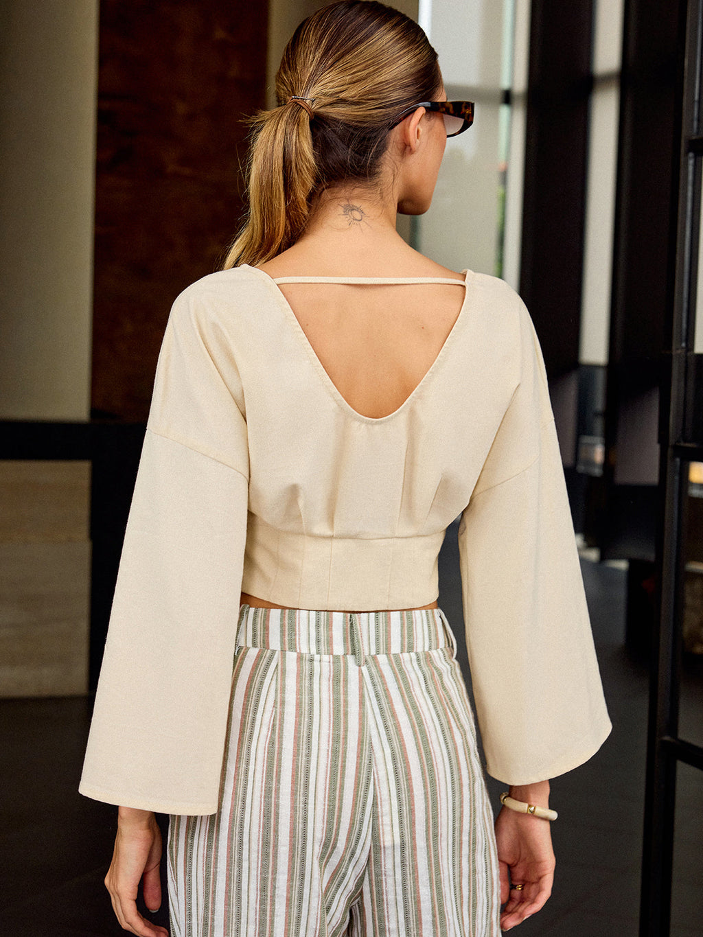 LA FINE FLEUR Slim Fit V-Neck Cropped Tee paired with striped linen pants.