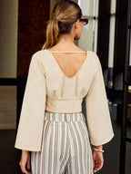 LA FINE FLEUR Slim Fit V-Neck Cropped Tee paired with striped linen pants.