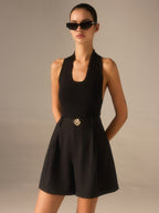 High-waisted shorts with chic metallic details and a sleeveless black top.