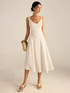 A midi dress with thin beige stripes and an asymmetrical hemline from LA FINE FLEUR.
