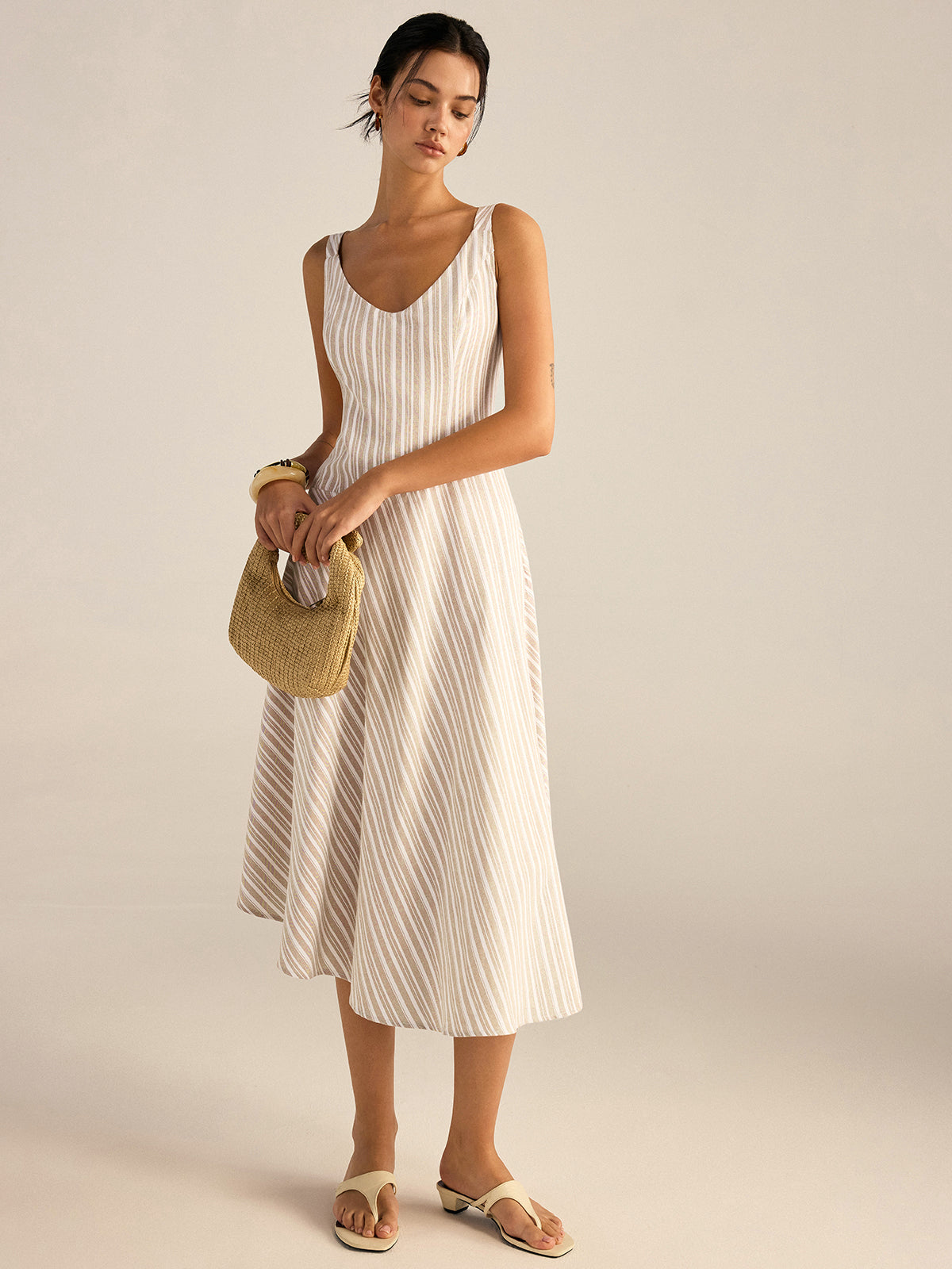 A beige and white striped midi dress with asymmetrical hemline and regular fit.