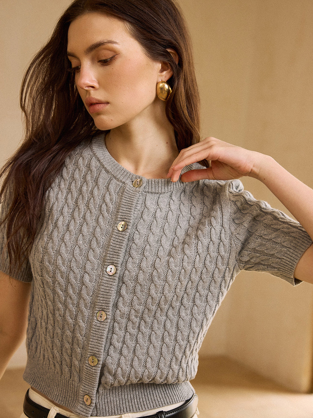 Light gray cable knit short-sleeve cardigan sweater with distinctive texture and relaxed fit.