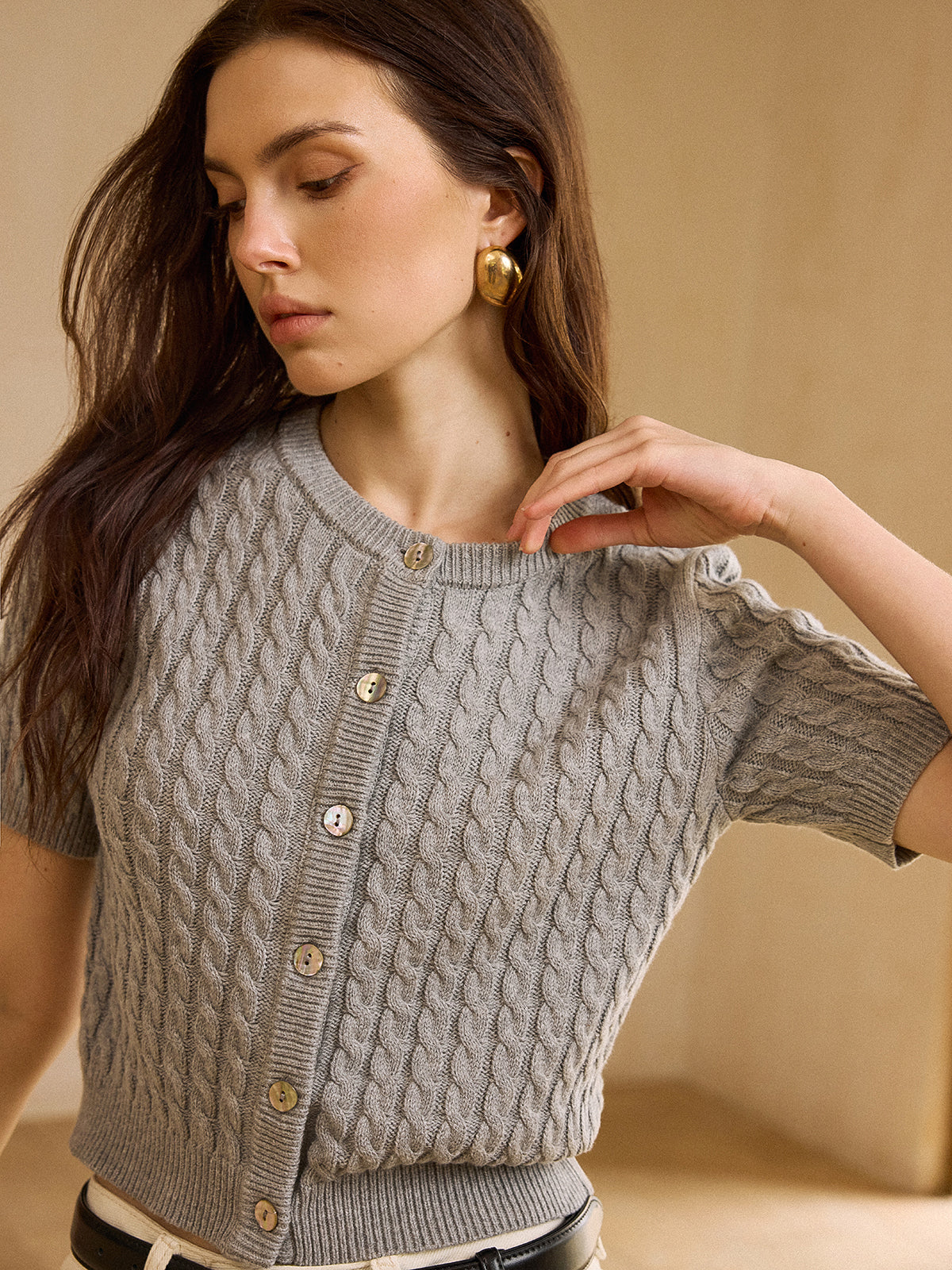 Light gray cable knit short-sleeve cardigan sweater with distinctive texture and relaxed fit.