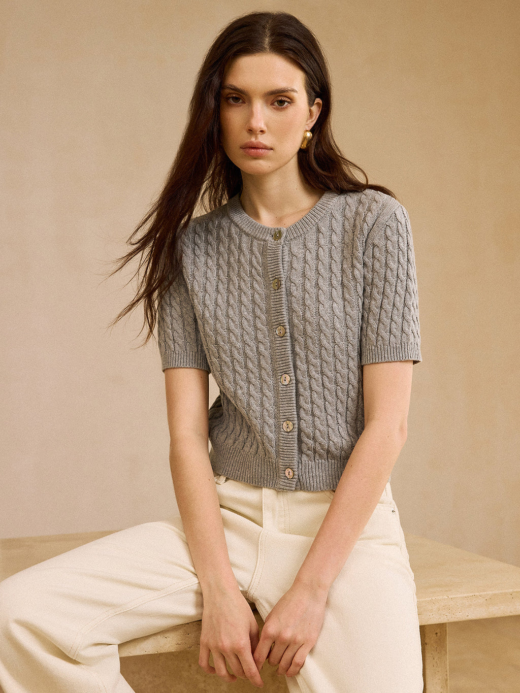Short-sleeve cable knit cardigan sweater paired with cream wide-leg trousers from LA FINE FLEUR.