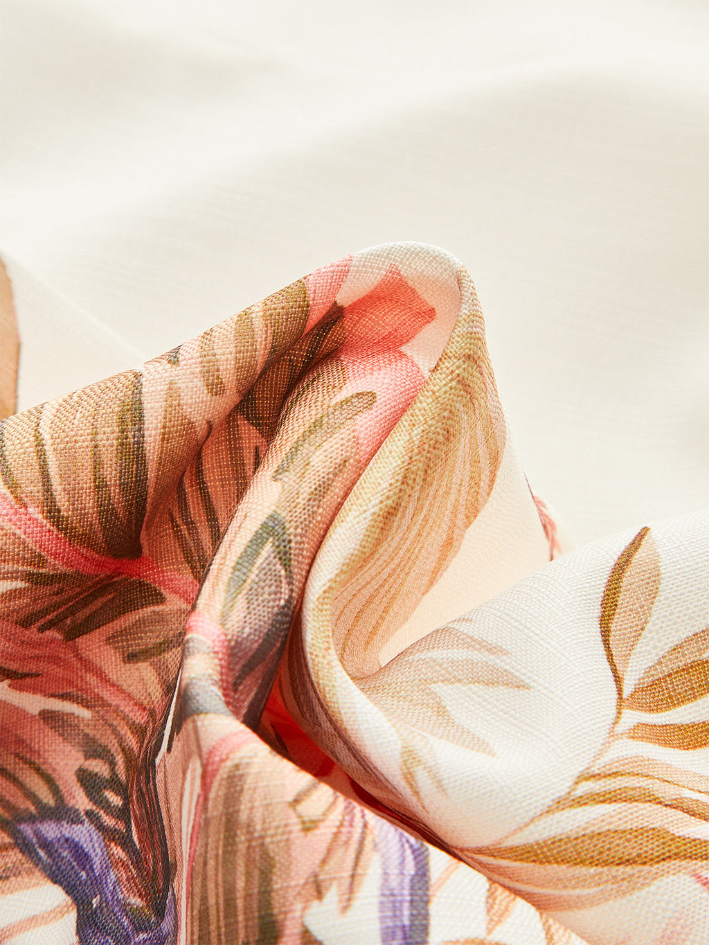 Mid-waist shorts in soft white fabric with pink, peach, and brown floral prints.