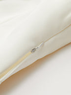 Wide-cut cropped blazer vest in cream, sleeveless, cinched waist, hidden zipper with white pull.