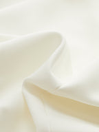 Wide-cut cropped blazer vest in soft white fabric, cinched waist, smooth gentle folds.