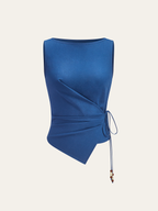Asymmetric sleeveless top with boat neck, draped front, and wrap-tie beaded embellishments.