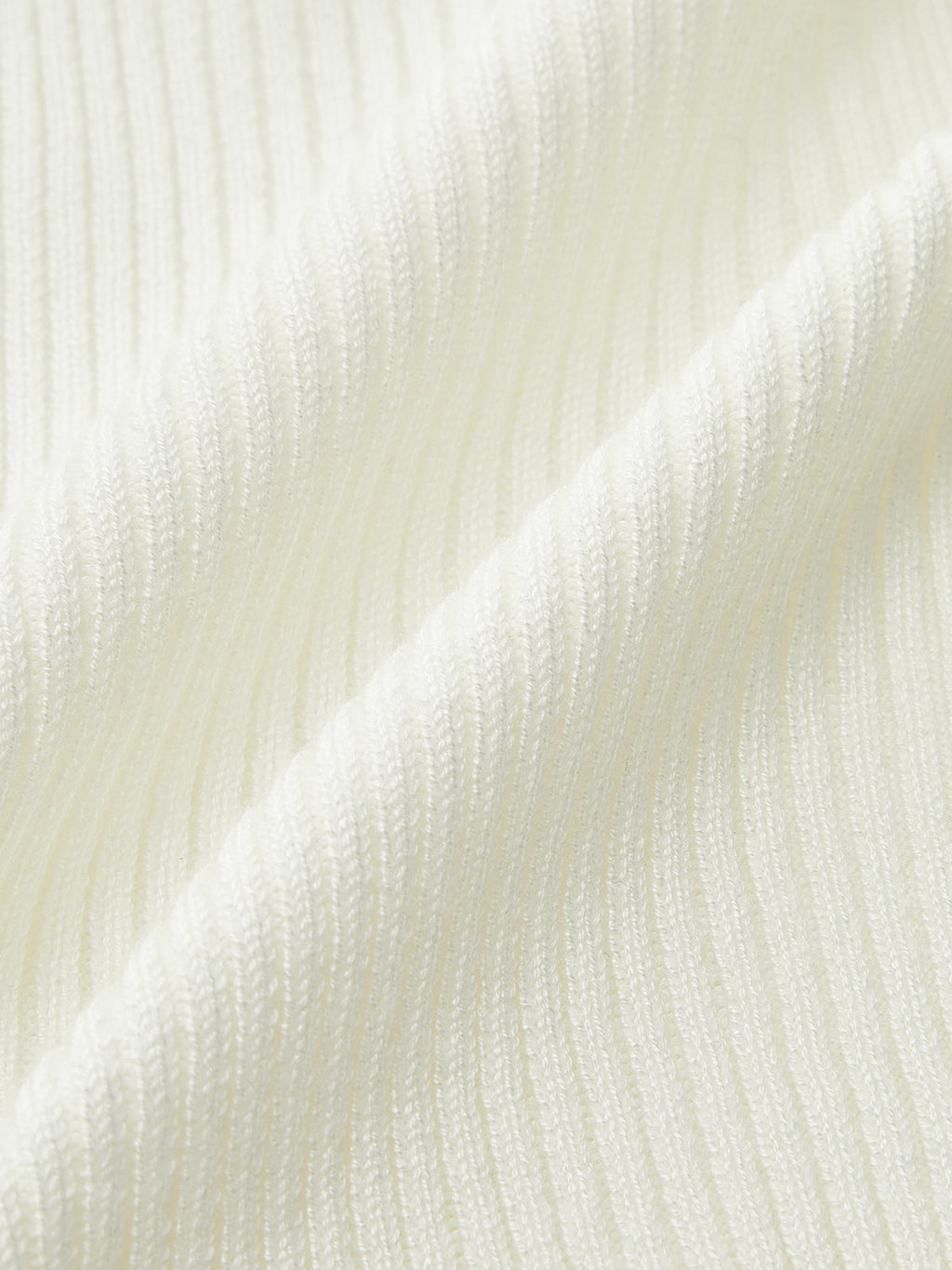 Ribbed knit cami top in soft white with metal button detail and sleeveless v-neck.