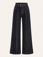 Wide-leg denim trousers with front pockets, bold white stitching, and a belted circular buckle.