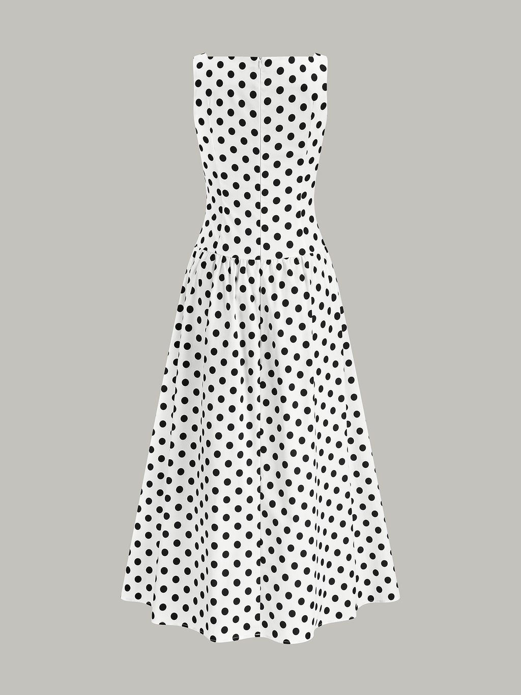 White sleeveless midi dress with a fitted bodice, flared skirt, and bold black polka dots.