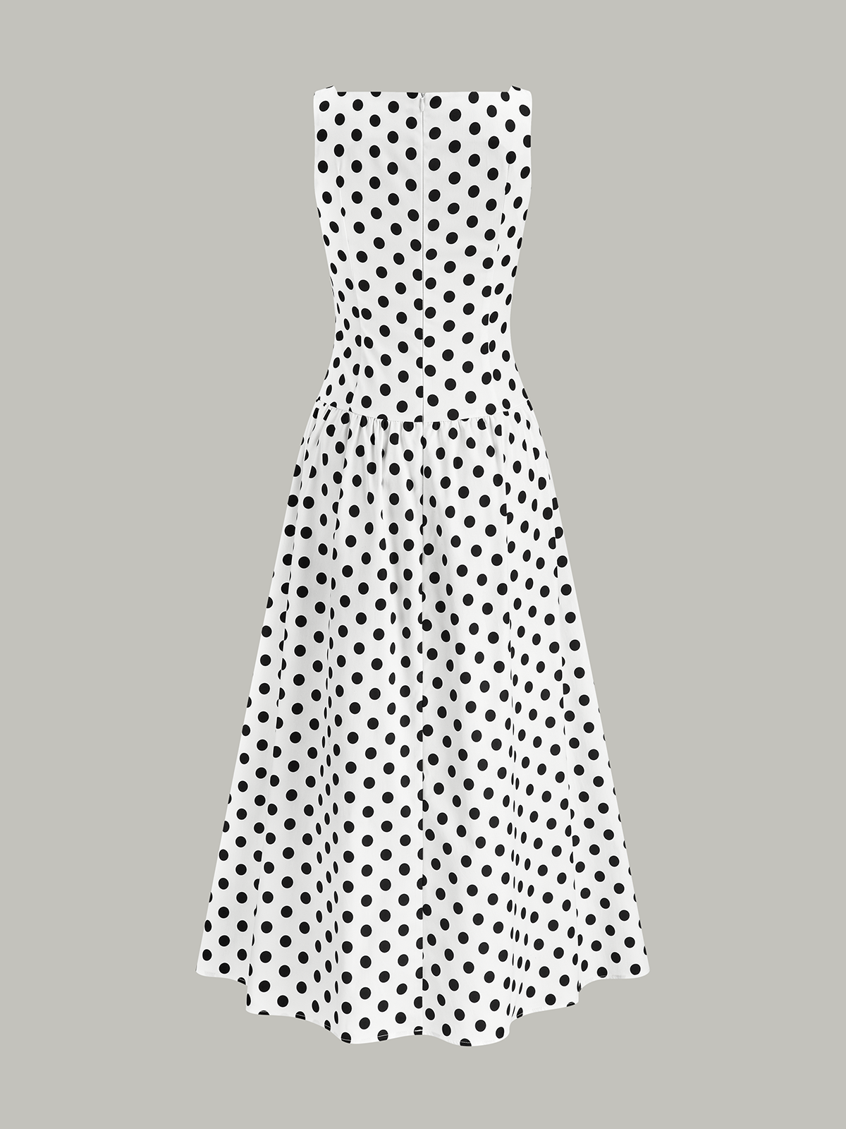 White sleeveless midi dress with a fitted bodice, flared skirt, and bold black polka dots.