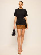 LA FINE FLEUR’s short-sleeve top with belt detail and a brown suede mini skirt.