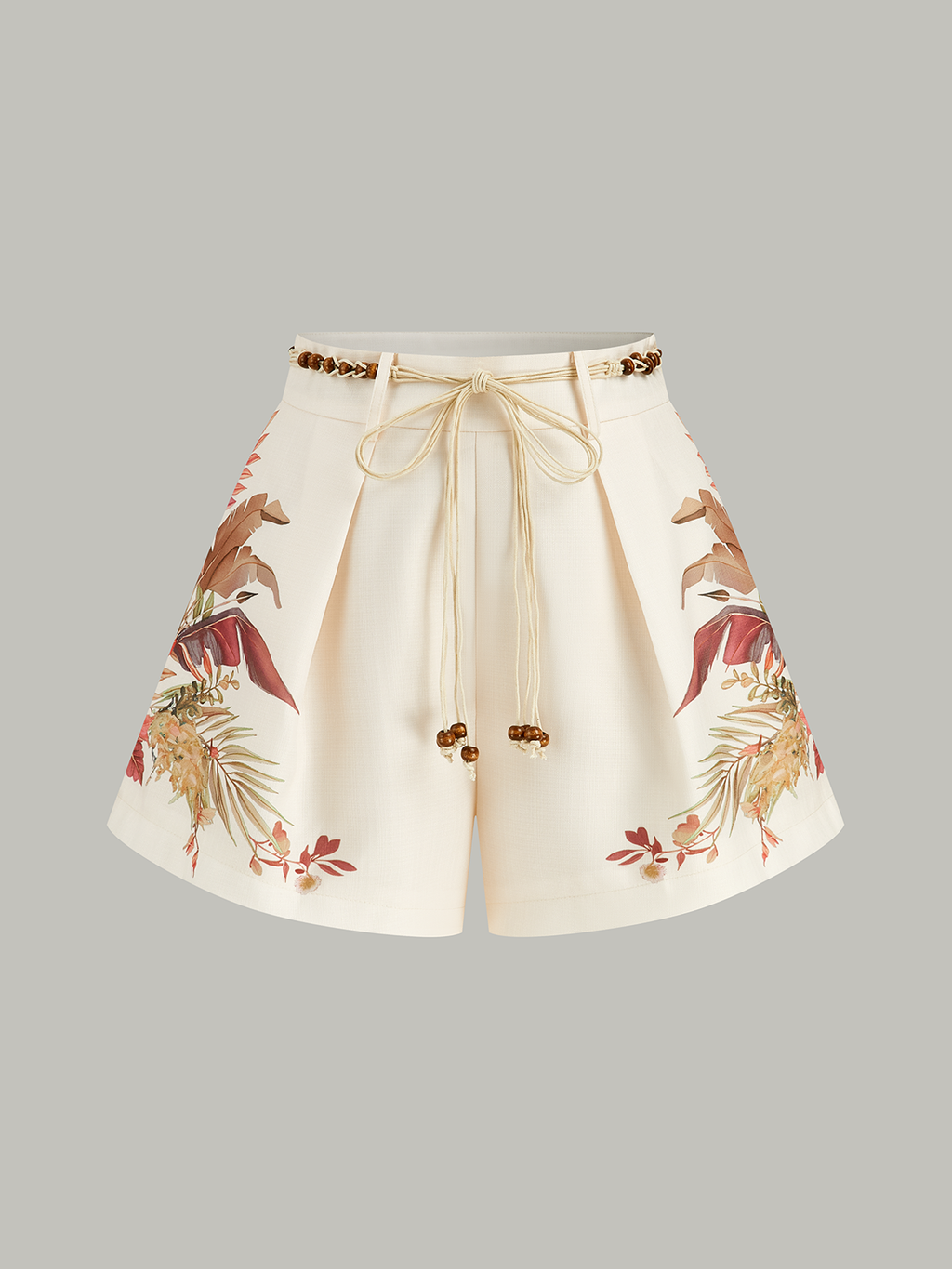 Cream mid-waist shorts with pleats, tropical beaded rope belt, and earthy floral print.