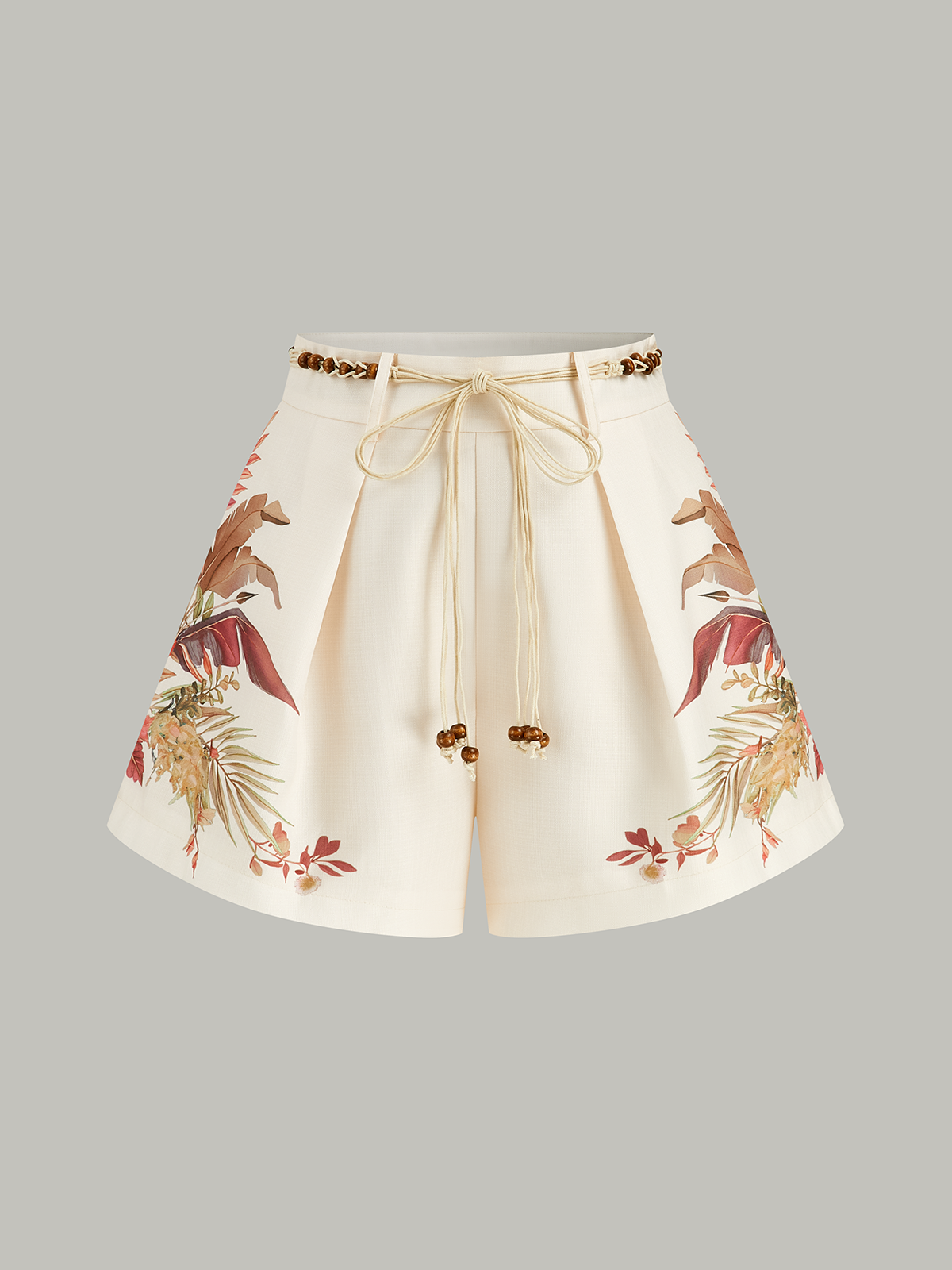 Cream mid-waist shorts with pleats, tropical beaded rope belt, and earthy floral print.