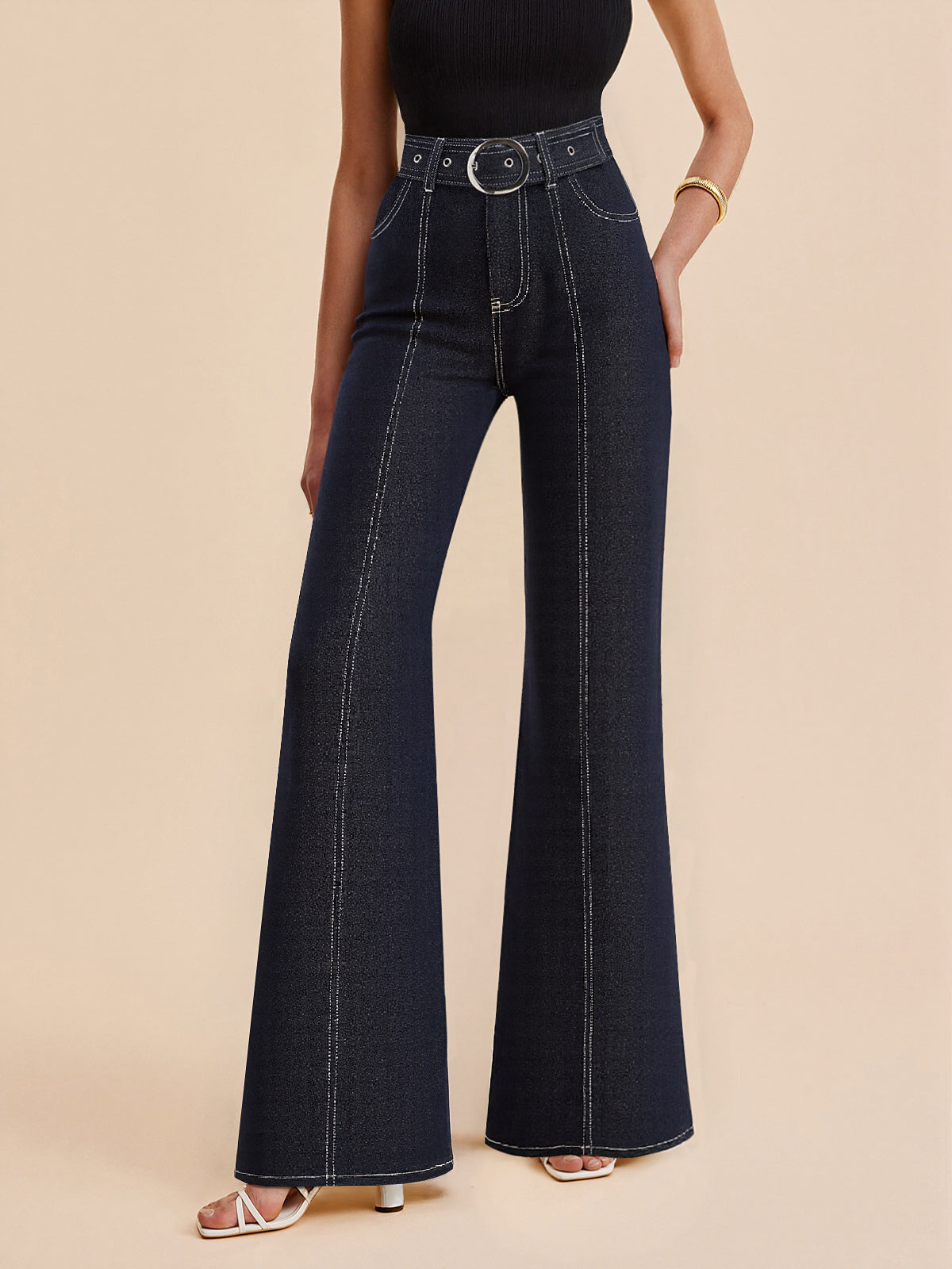 High-waisted dark blue denim trousers with contrast stitching and a belted waist, paired with a black sleeveless top.