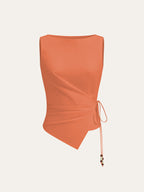 Vibrant orange sleeveless top with boat neckline, asymmetric hem, and beaded wrap-tie detail.