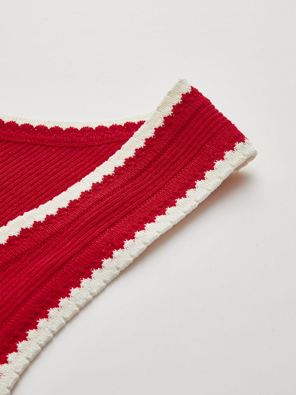 Red ribbed knit tank top with scalloped white zigzag trim along the edges.