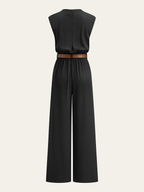 Mock neck jumpsuit with brown belt, wide legs, fitted waist, and upper back zipper.