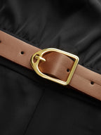 Black mock neck jumpsuit with wide legs and brown leather belt featuring gold buckle.