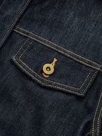 Dark blue cropped denim top with yellow stitching, pointed flap pocket, brass-tone button.
