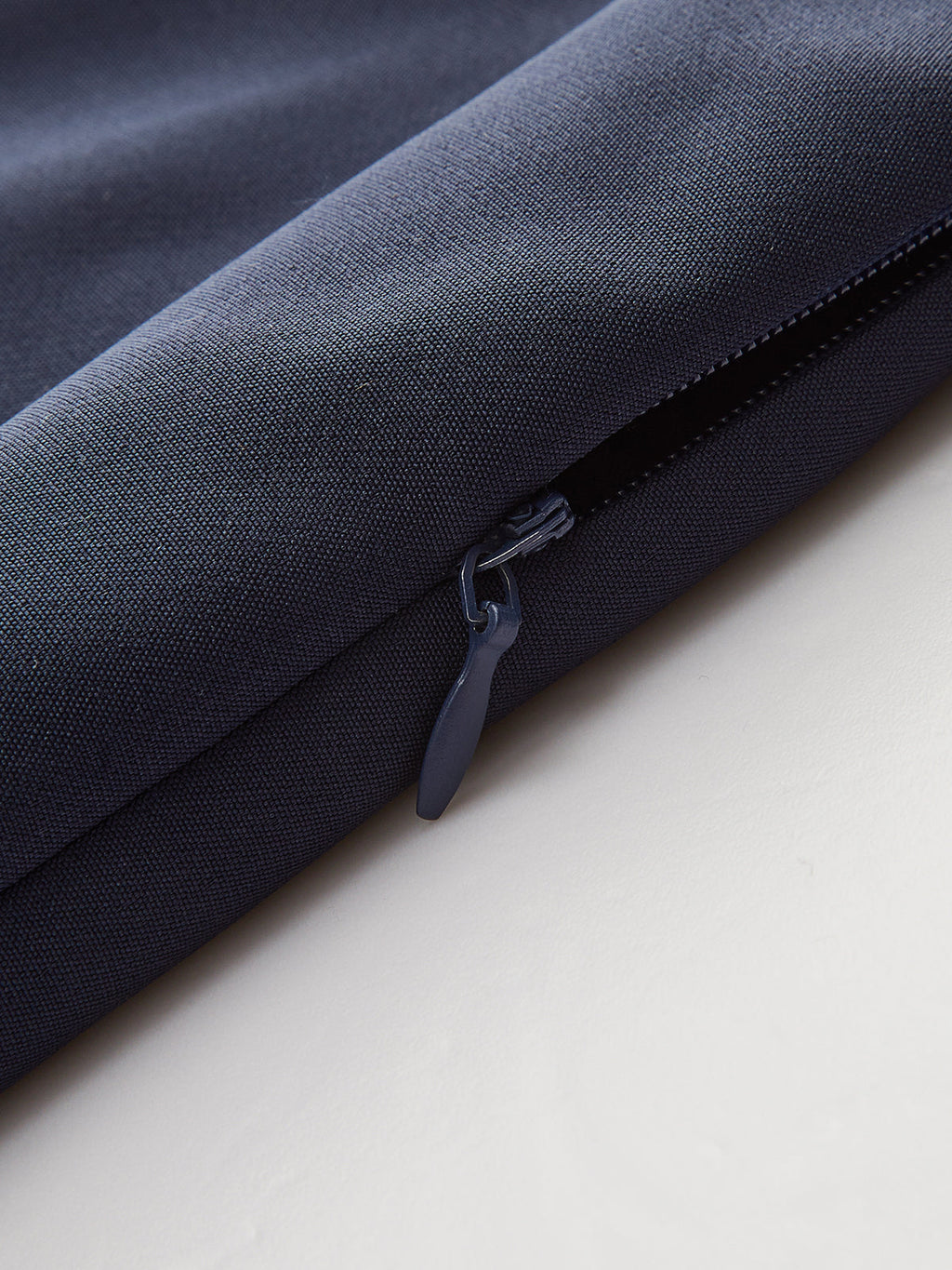 Navy asymmetrical skort with metallic accents and a blue partially opened visible zipper.