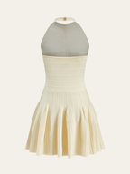 Cream backless halter sweater dress with ribbed bodice, neck detail, zipper, and pleated skirt.