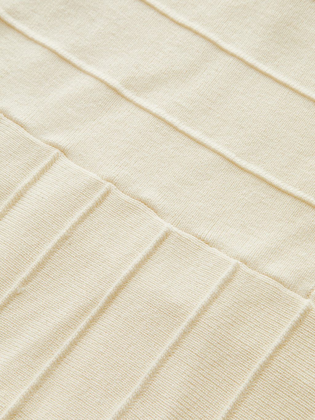 Beige ribbed knit dress with neck detail, highlighting textured fabric and intricate stitching.