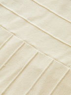 Beige ribbed knit dress with neck detail, highlighting textured fabric and intricate stitching.